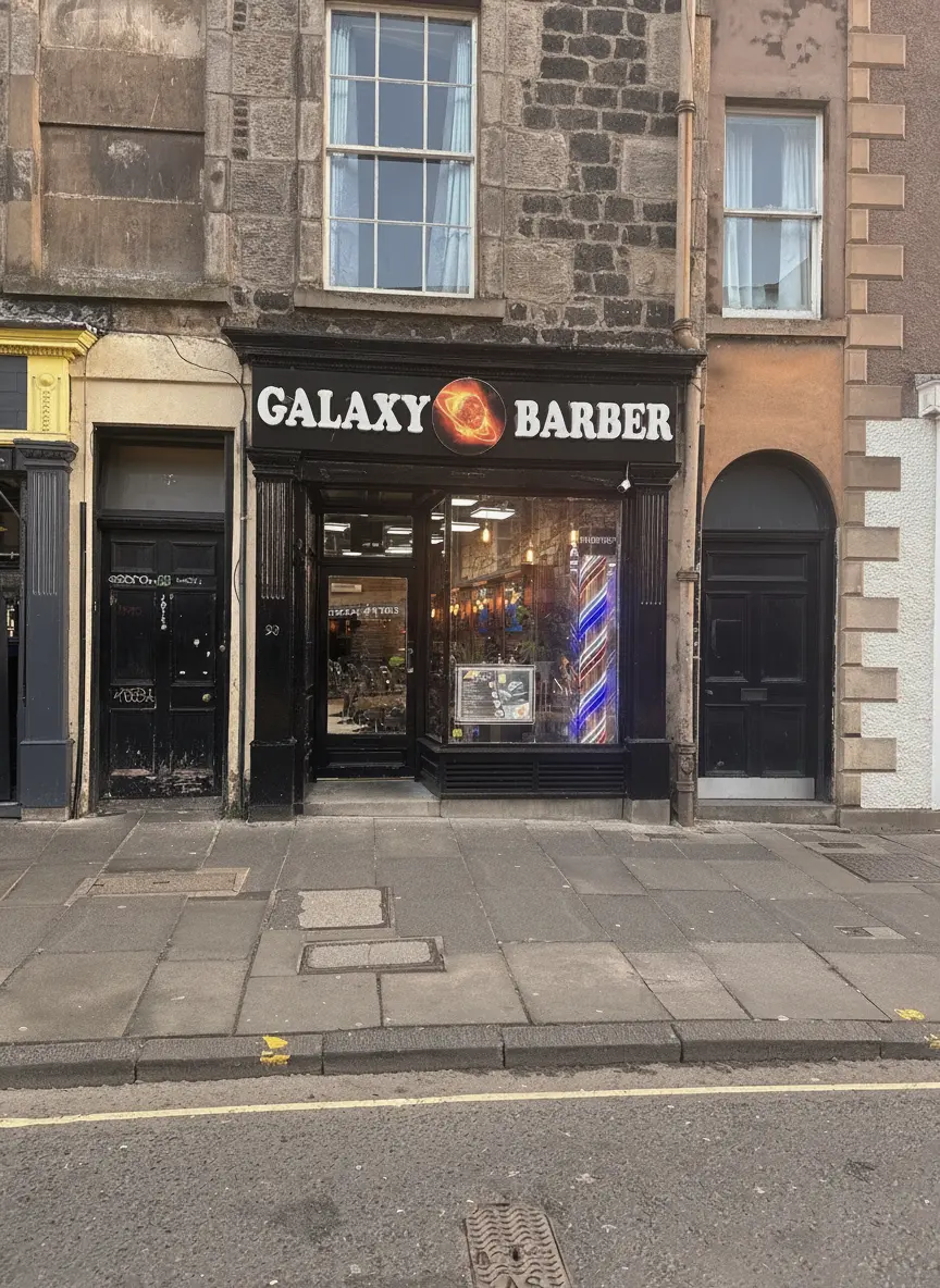 Galaxy Barber's black shopfront on Nicolson Street, Edinburgh, with its GALAXY BARBER sign and ringed-planet logo
